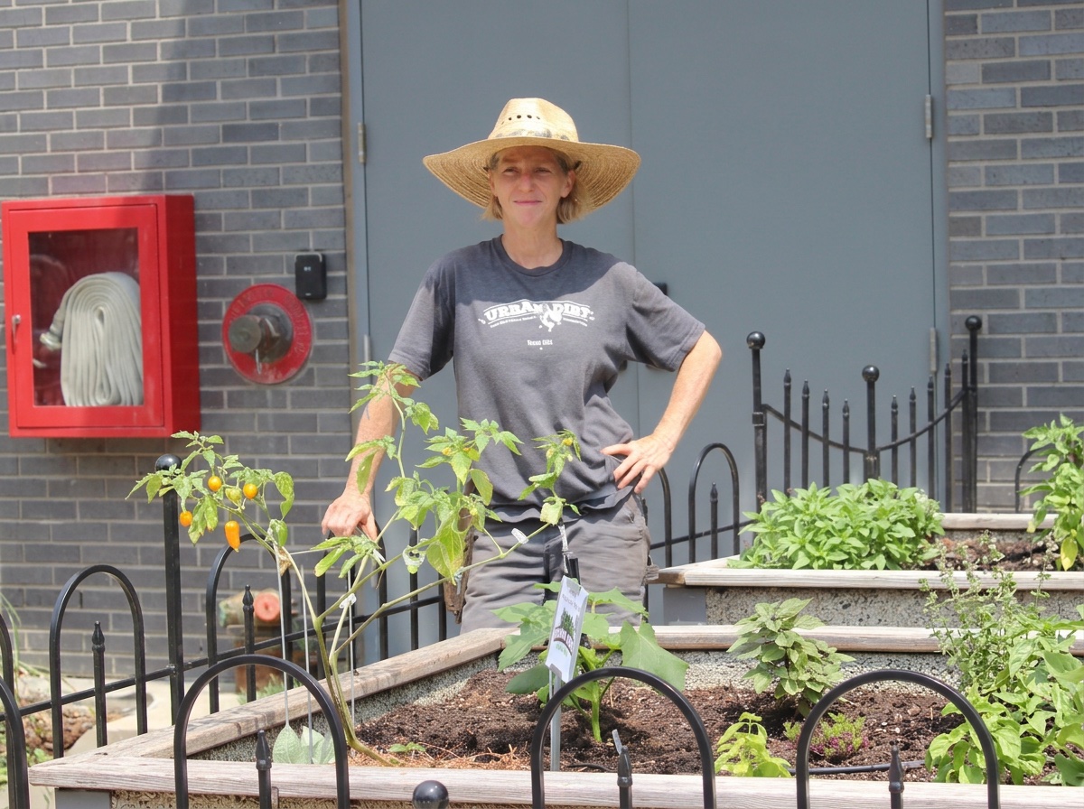 Piper in a wide-brimmed hat among the raised beds of the Virgin Hotel garden